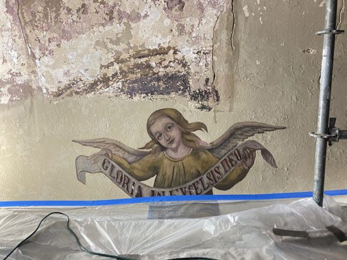 Paint exposure revealing some of the background of the Nativity mural.